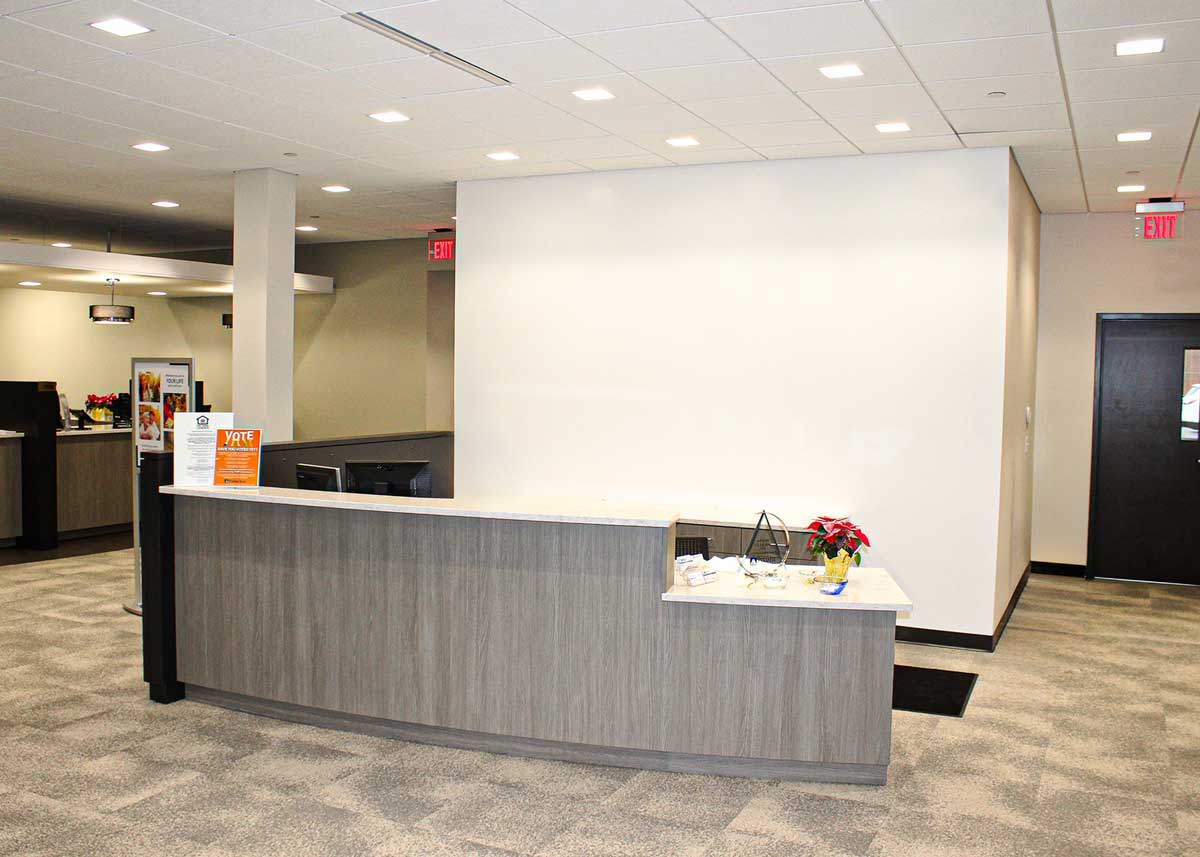 Blank PyraMax Bank wall behind a rounded front desk before custom graphics were installed.