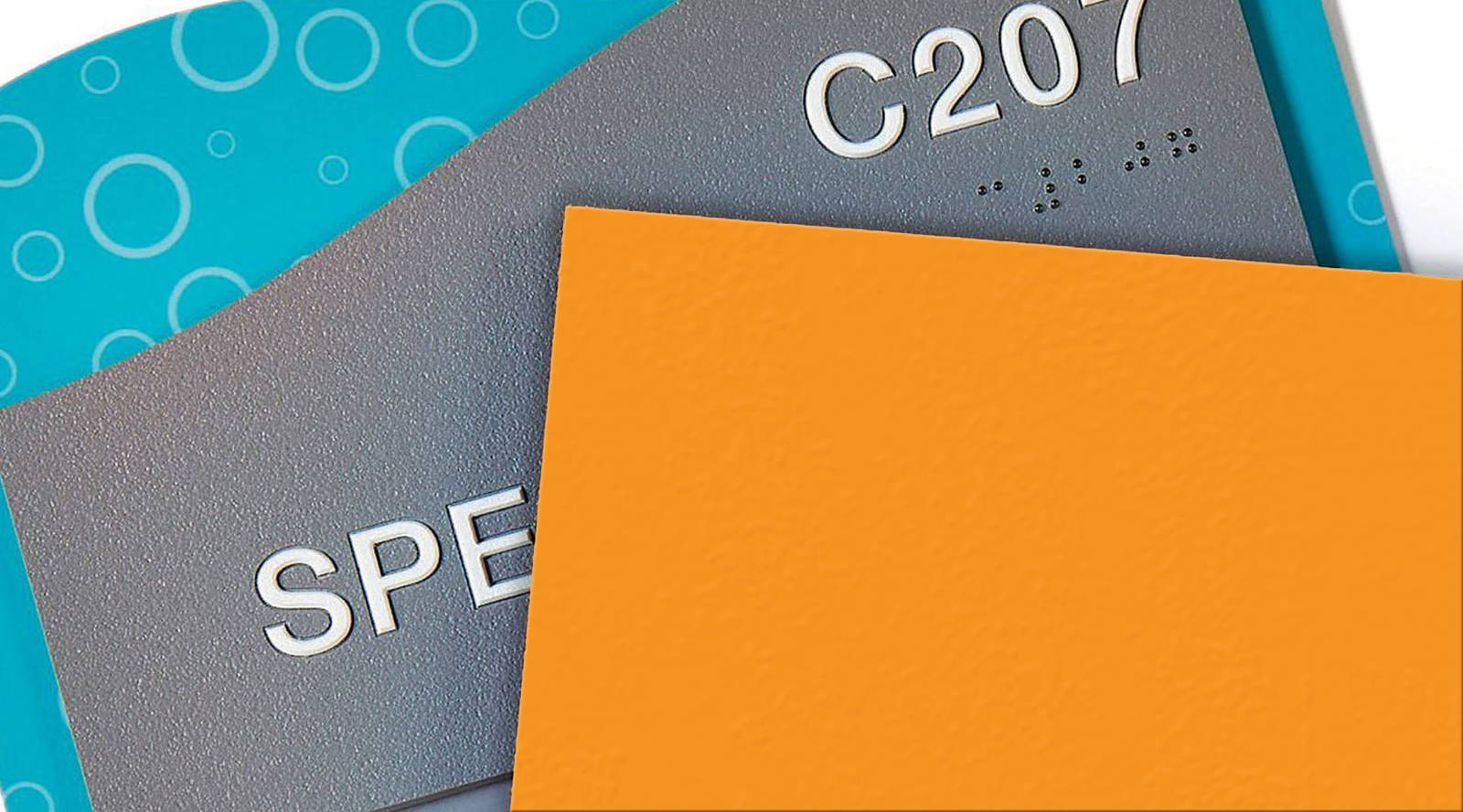ADA-compliant room signs with raised lettering, high-contrast colors, and Braille, including text like “C207.