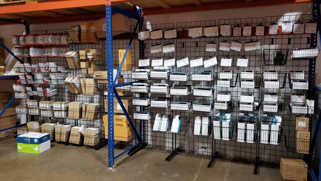 An organized wall of printer supplies and replacement parts.