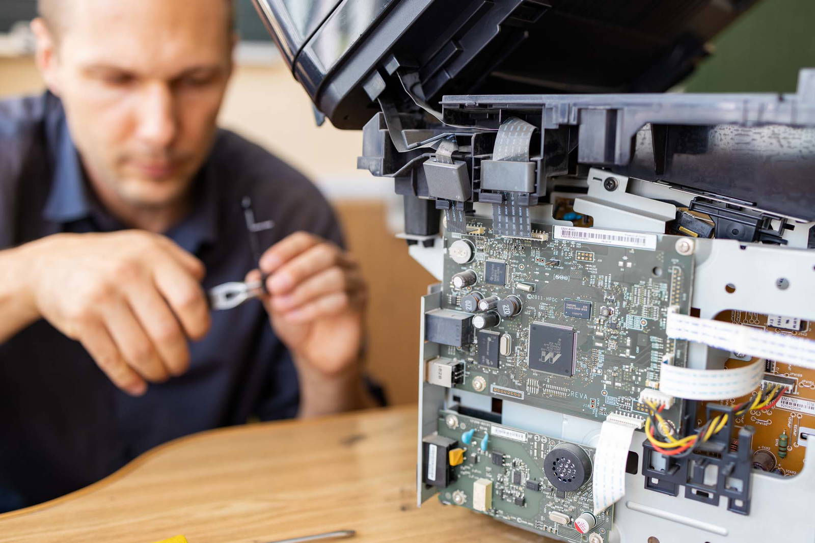 Printer repair technician working on a machine.