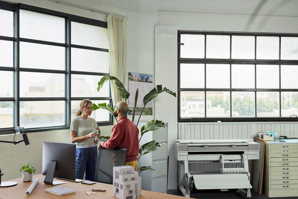 Man and woman standing near HP printer