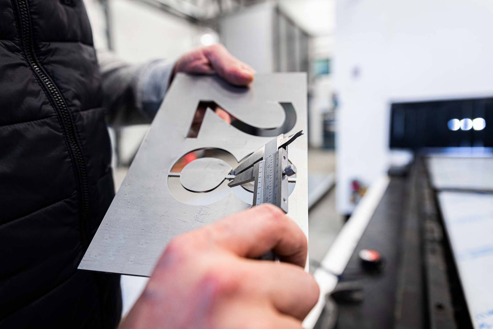 Person working on finishing a metal sign.