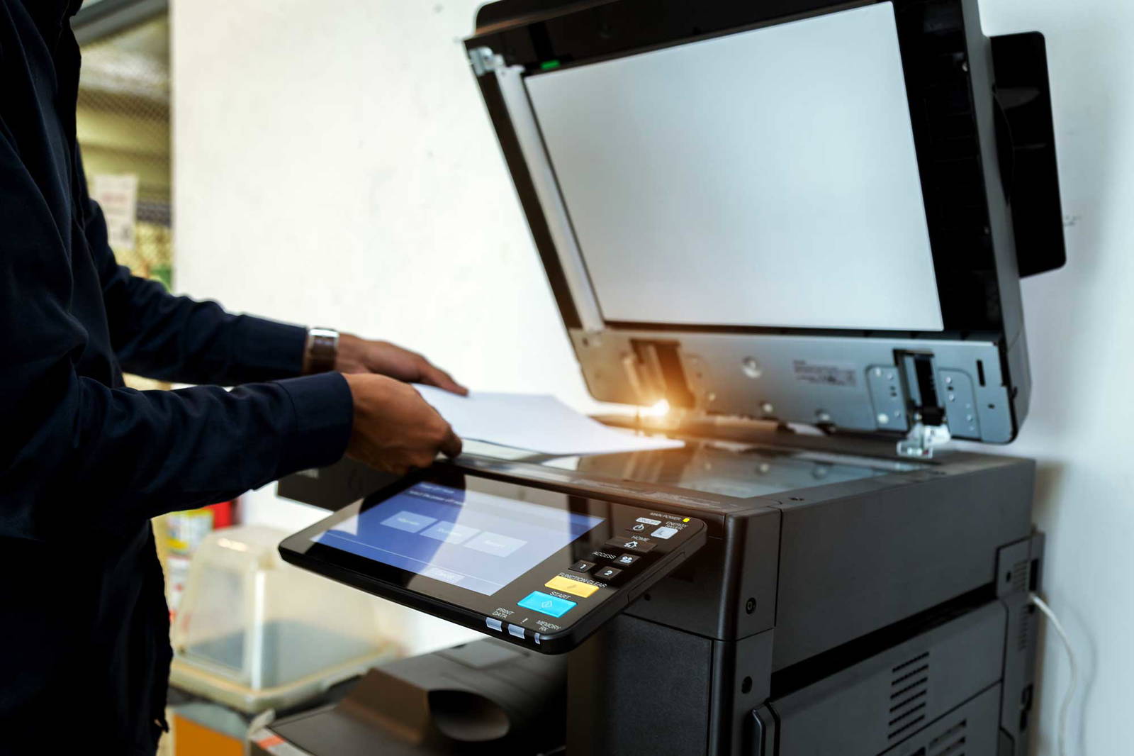 Person inserting a paper into a scanner.