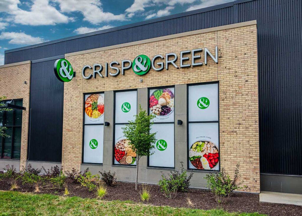 Crisp & Green restaurant exterior window signage displaying their logo and images of their food.