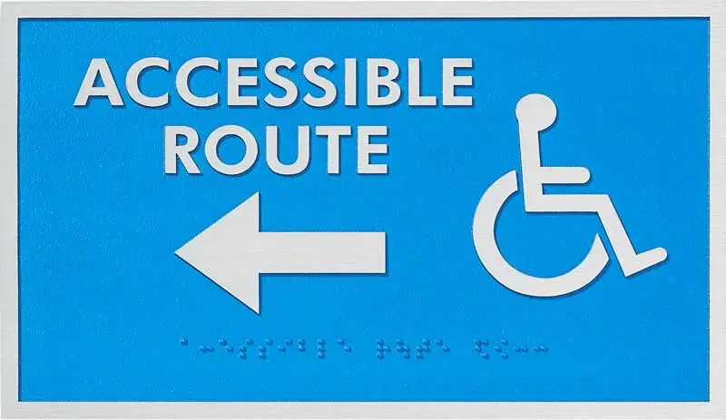 ADA Signage featuring a blue tactile "Accessible Route" sign with a left-pointing arrow, wheelchair symbol, and braille text for wayfinding compliance.