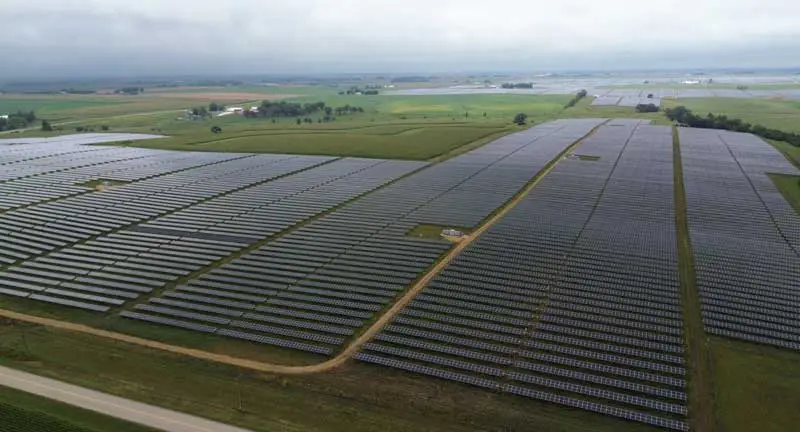 December 2024 Monthly Newsletter 6 Badger Hollow Solar Farm aerial view of expansive solar panel arrays stretching across rural Wisconsin farmland under a cloudy sky.