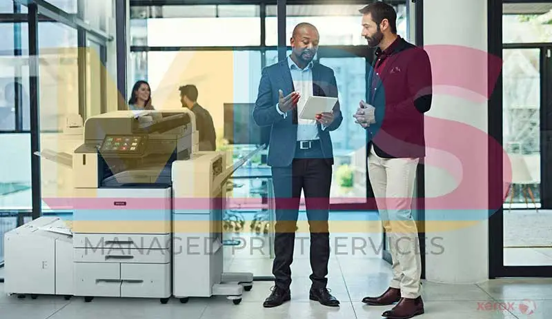 Managed Print Services for Xerox Printers featuring two professionals discussing print solutions beside a Xerox multifunction printer in a modern office setting.