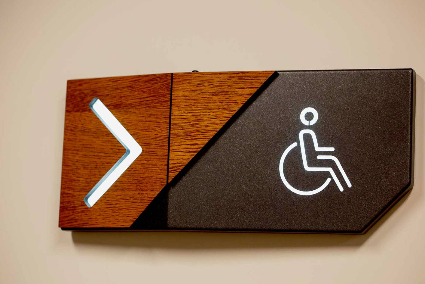 Toilet sign for disabled people with direction arrow on the wall.