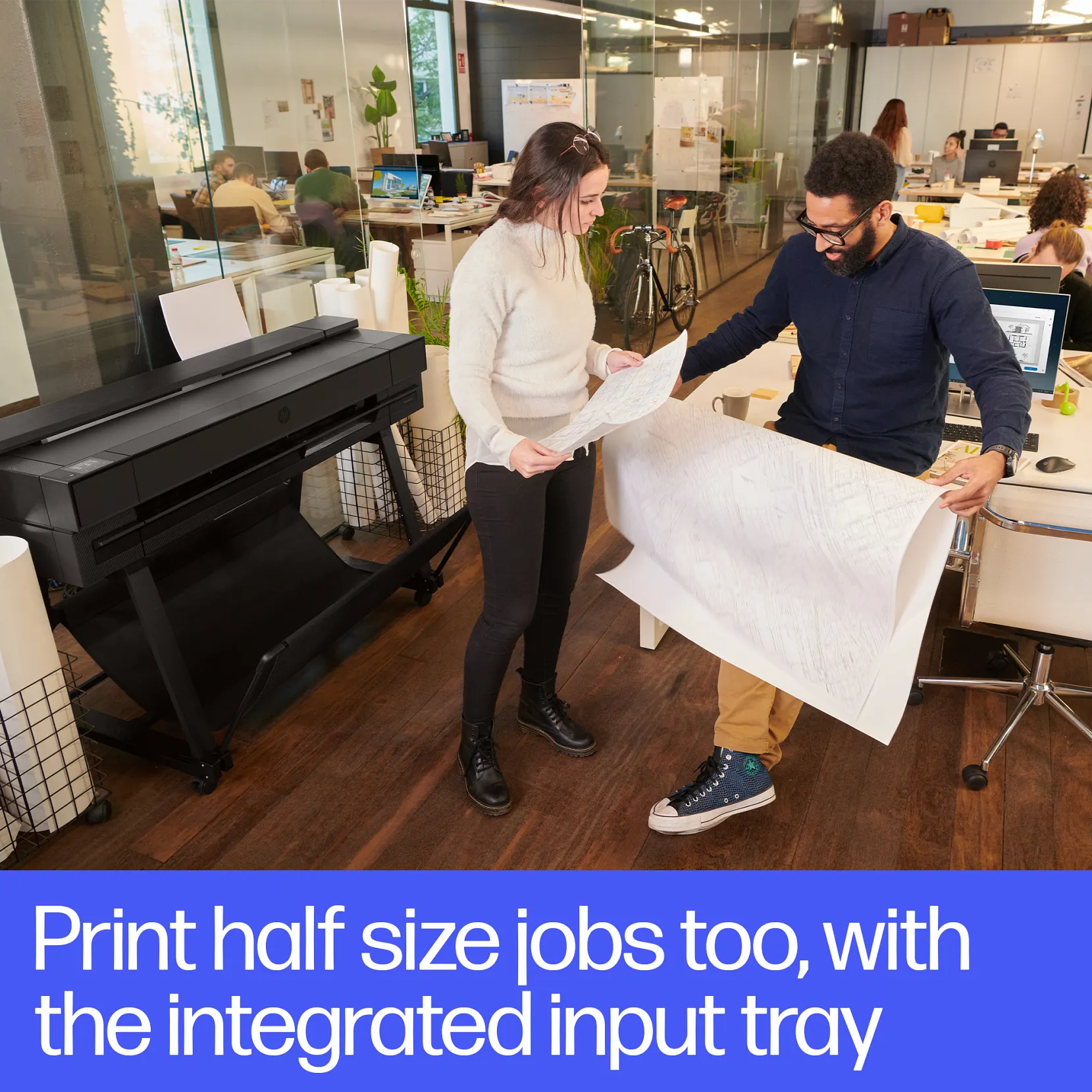 HP DesignJet XT850 5 Male professional in blue long sleeved shirt looking at large format print with female coworker in white shirt looking at them as well. HP Designjet T850 printer plotter behind them.