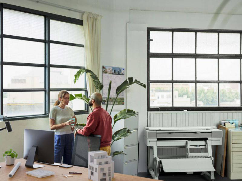 Man and woman standing near HP printer