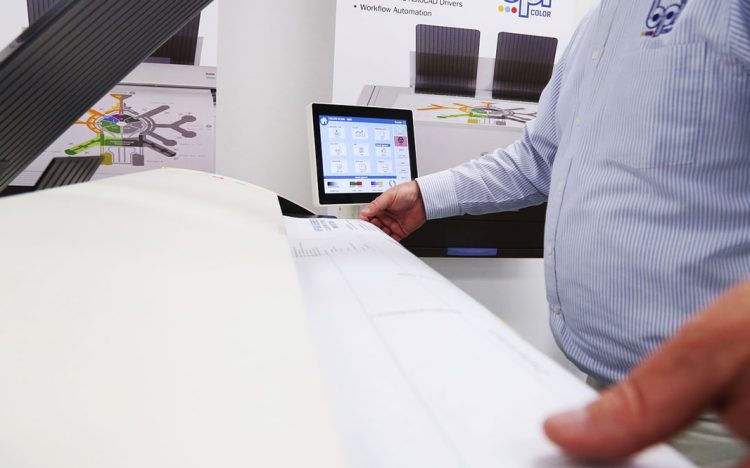 Blueprint Scanning process shown with a wide-format scanner and a BPI Color technician operating the touchscreen interface to digitize architectural plans.